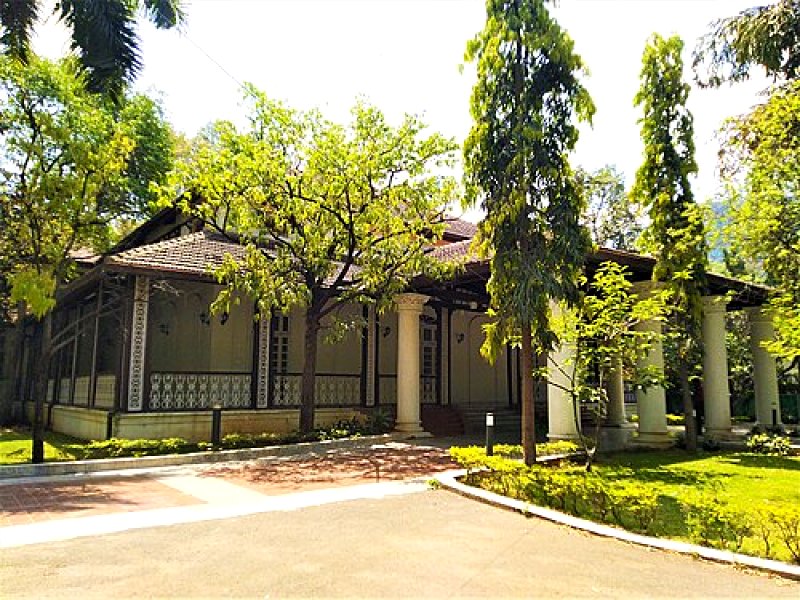 Colonnaded Indian bungalow with a tiled roof and verandah
